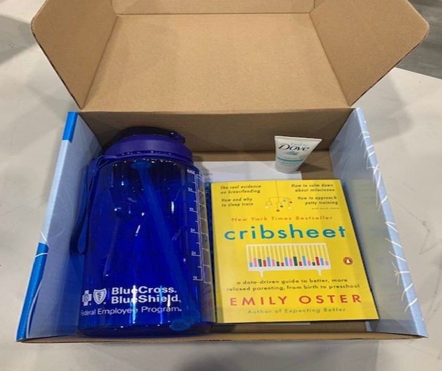 A box, packed with a Blue Cross Blue Shield waterbottle and a copy of Cribsheet by Emily Oster.